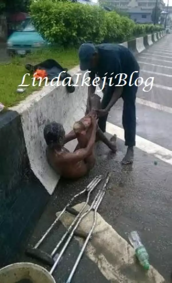 Really Touching!! Man Spotted Bathing A Mad Man On Herbert Macaulay Way, Yaba [See Photos]